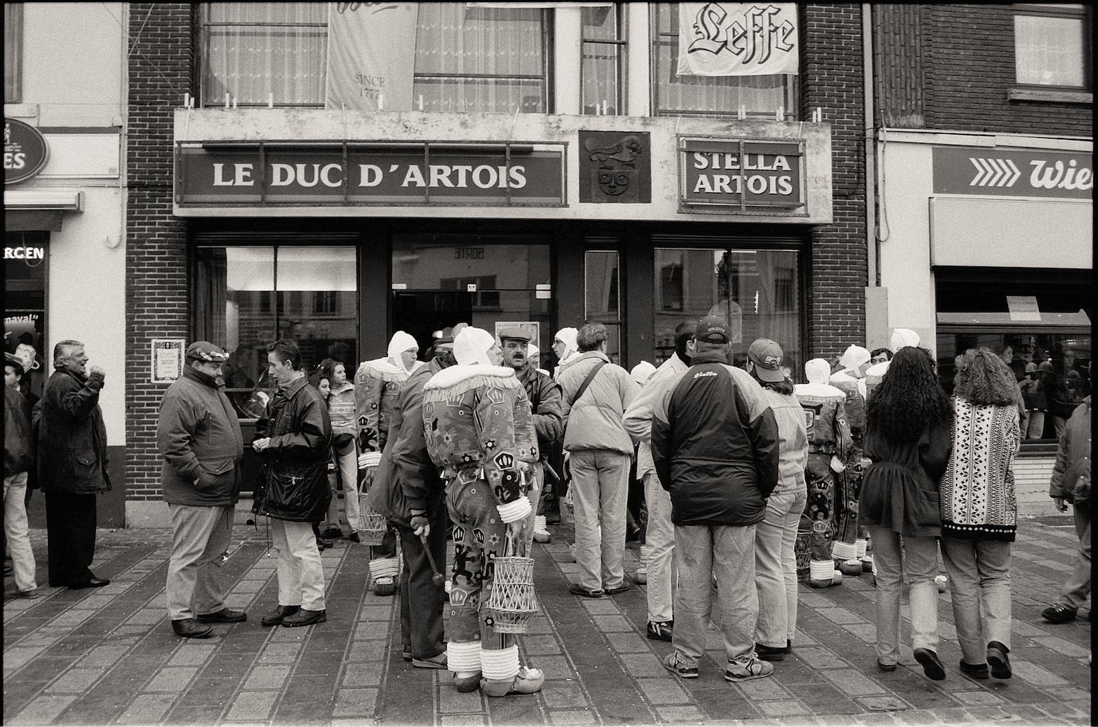 Group of People Standing in Queue in Black and White